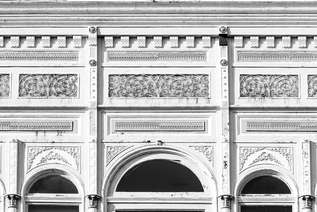 Black and white photograph of the details in an ornate ironwork historic storefront in downtown Natchez, Mississippi.