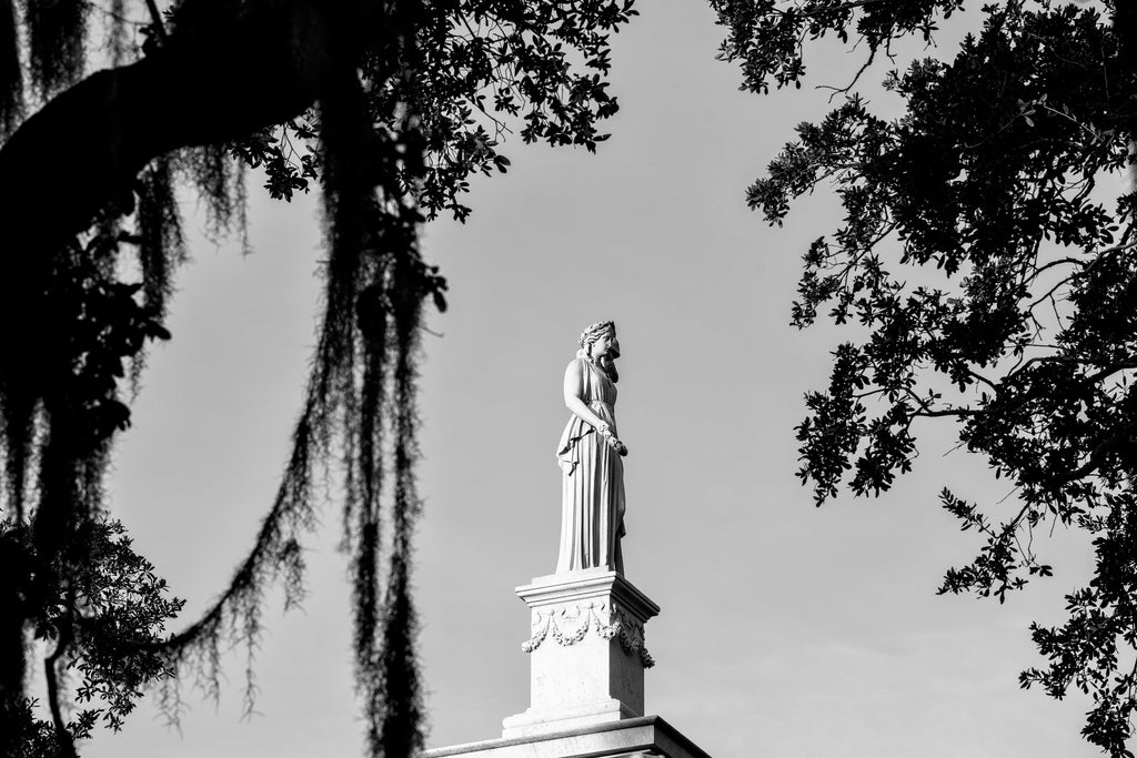Black and white photograph of the statue on top of the Casimir Pulaski monument in Monterey Square in Savannah, Georgia.