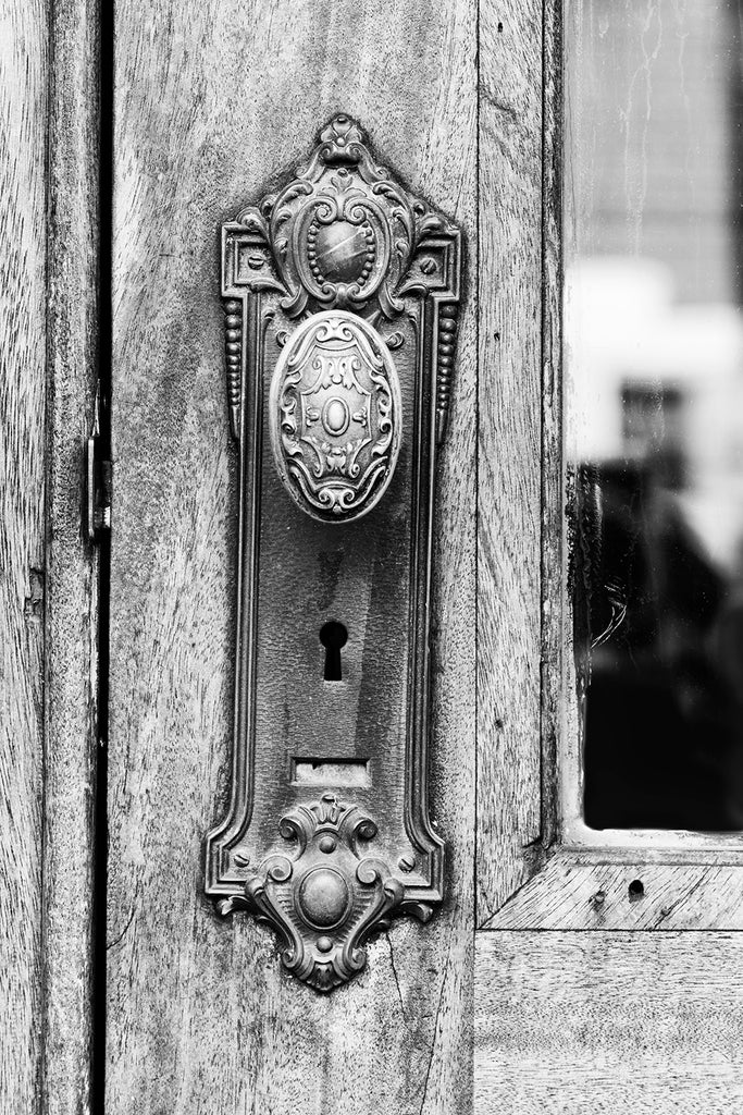 Black and white photograph of a beautifully decorative old door knob on an office building in a small city in the American South.