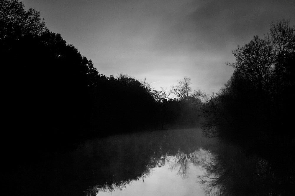 Black and white photograph of Bayou Teche, near Lafayette Louisiana, with the sun rising through the fog.