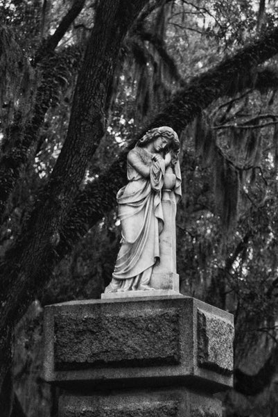 Black and white photograph of the statue on the entrance gate to Savannah's famous, beautiful, and creepy Bonaventure Cemetery.