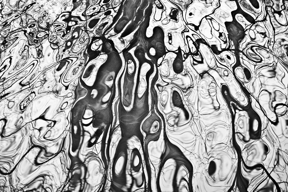 river abstraction Ripples of a stream reflecting barren tree branches in a mesmerizing way