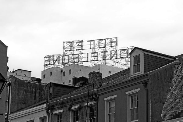Black and white photograph of rooftop sign of the Hotel Monteleone, seen from behind, in New Orleans' famous French Quarter. 