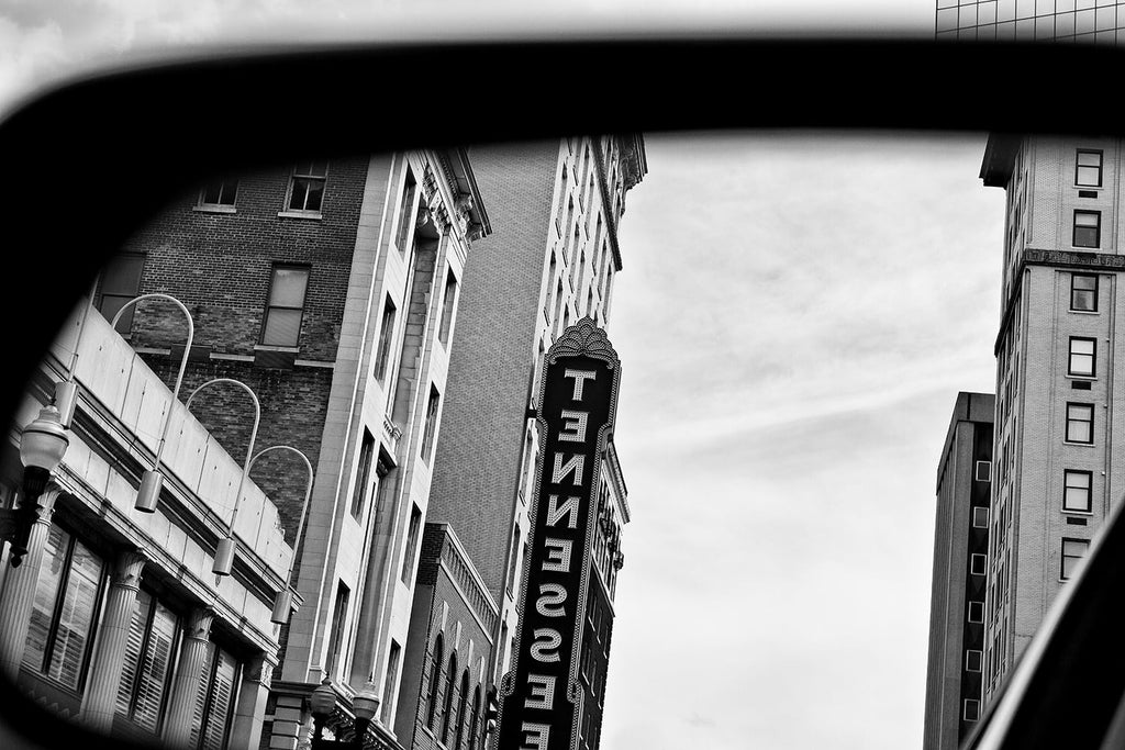 Black and white photograph of the famous Tennessee Theatre sign in Knoxville, reflected in a car's rearview mirror.