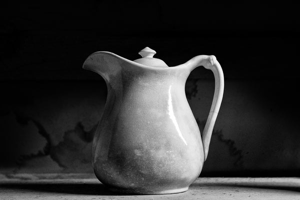 Black and white photograph of a simple and beautiful antique white pitcher with a gorgeous craquelure surface within the glaze