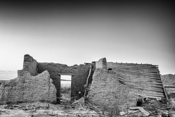Black and white photograph of an abandoned and collapsed adobe ruin in the desert of west Texas.