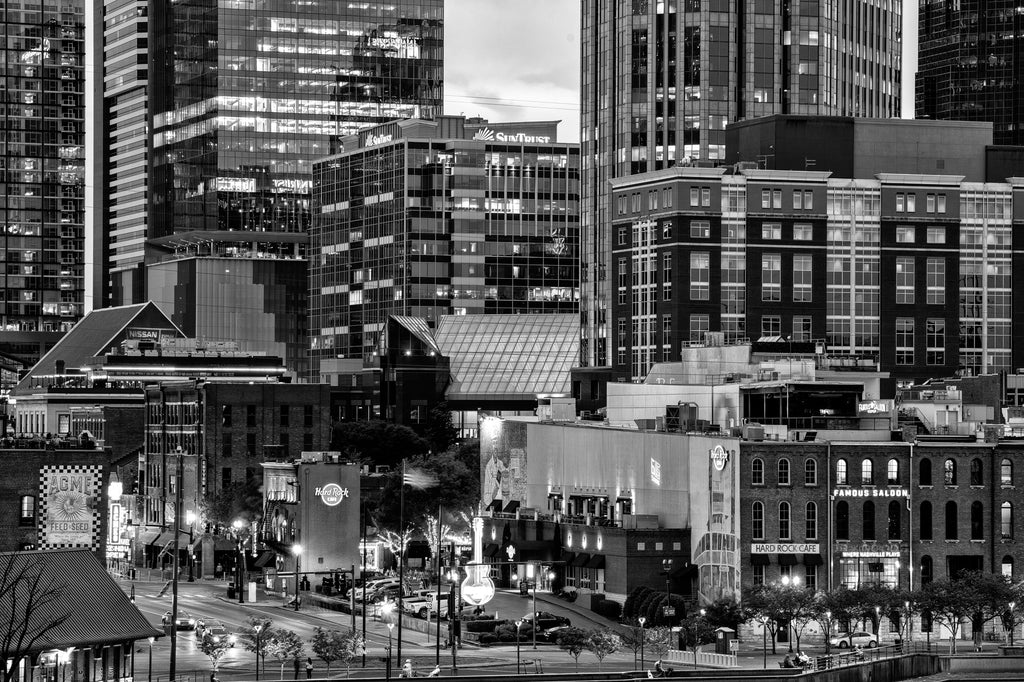 Black and white photograph of the Nashville skyline and historic waterfront at night. 