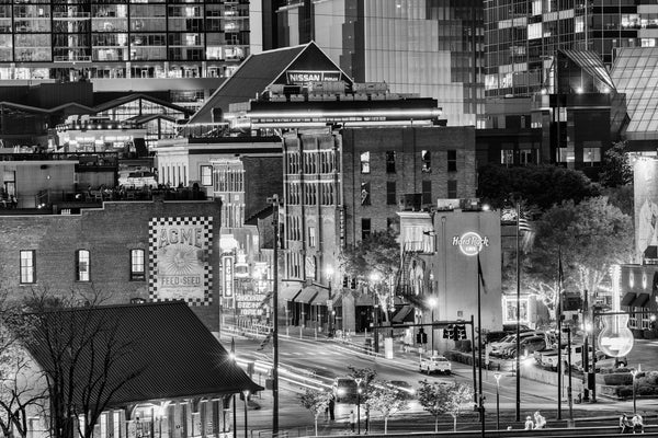 Black and white photograph of Nashville's Broadway entertainment district at night, as seen from across the Cumberland River.