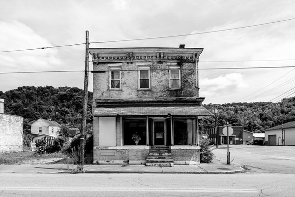 Black and white photograph of a vacant historic storefront, date unknown, in South Wheeling, West Virginia.
