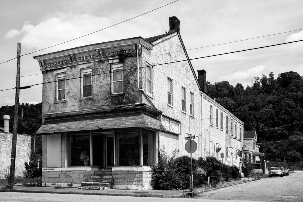 Black and white photograph of a vacant historic storefront, construction date unknown, in South Wheeling, West Virginia.