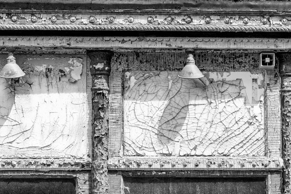 Black and white photograph of cracked paint textures on an abandoned storefront built in 1891.