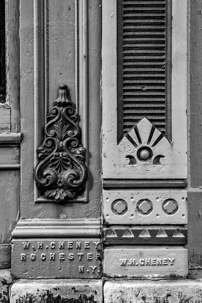 Black and white photograph of decorative architectural ironwork by W.H. Cheney seen on old buildings in downtown Rochester, New York.