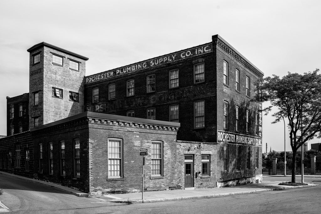 Black and white photograph of the old Rochester Plumbing Supply building, which has been an apartment building since 2015, but was a plumbing supply company from 1920. Prior to that, it was home a marshmallow company.