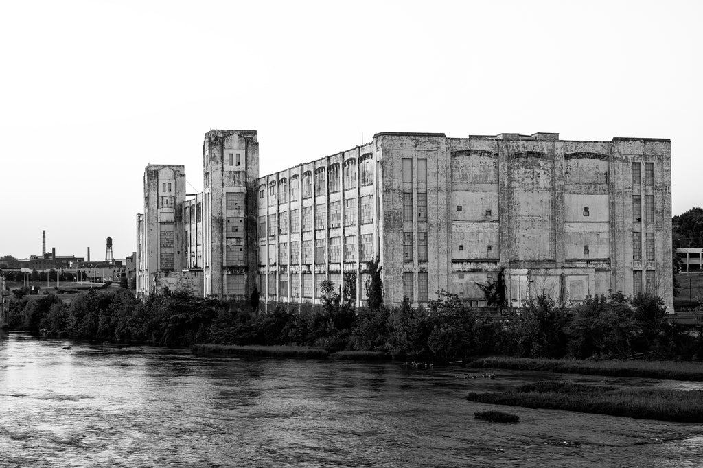 Black and white photograph of the abandoned Dan River Mills which sits along the bank of the Dan River in Danville, Virginia. Opened in the 1880s, it became the largest textile mill in the South and remained in business until 2006.