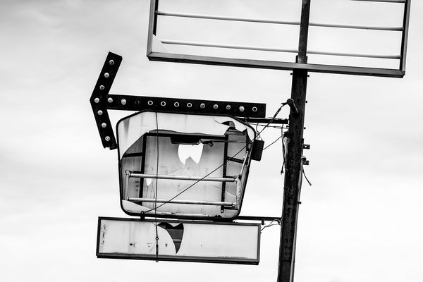 Black and white photograph of the components of a broken commercial sign in Cairo, Illinois.