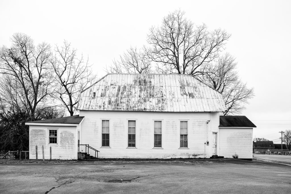 Black and white photograph of an abandoned church building in a small southern town.