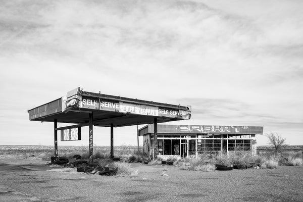 Black and white photograph of an abandoned and vandalized gas station in the barren Texas Panhandle.