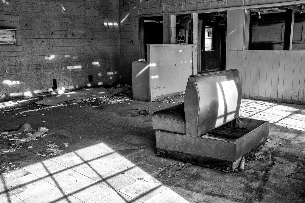 Black and white photograph of an old padded seat inside the abandoned Texas Longhorn Motel and Restaurant along Route 66 in the Texas Panhandle.