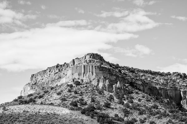 Black and white landscape photograph of a high stone mesa in the desert between Santa Fe and  Bandelier, New Mexico.