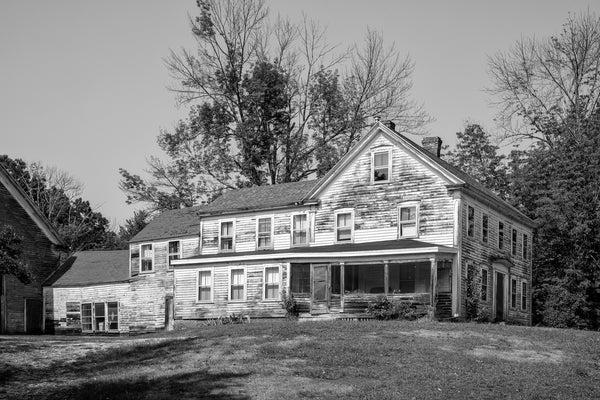 Black and white photograph of a big historic New Hampshire farmhouse built in 1868 and currently sitting vacant.
