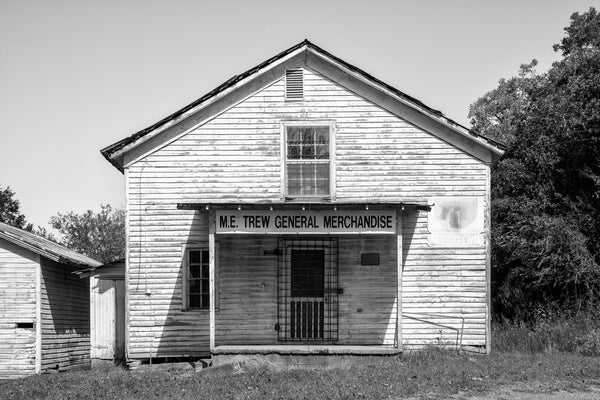 Black and white photograph of the Trew General Merchandise Store in East Tennessee. The first building was constructed in 1890 by J.W. Trew, and the second opened in 1903. The store was managed by M.E. Trew from 1925 until his death in 1996, when the store was closed permanently.