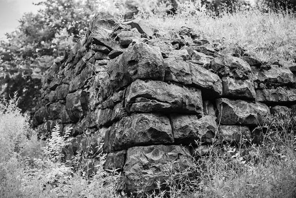 Black and white photograph of the old limestone walls of Fort Negley on a hillside near Nashville. Fort Negley is a star-shaped structure built of limestone blocks on a hilltop south of the city, and was the largest inland fort built during the American Civil War. The fort was built by the Union army in 1862 as a defensive post after the Confederates lost control of Nashville in successive battles, but with fighting concentrated in other areas, the fort never saw action. 