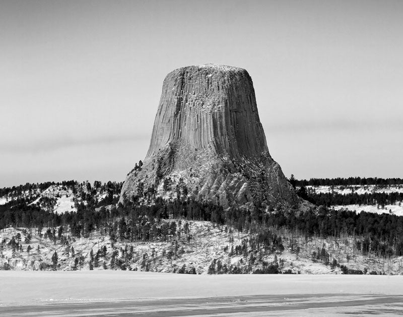 Black and white winter landscape photograph focused on Devil's Tower in Wyoming, made famous by the movie "Close Encounters of the Third Kind."