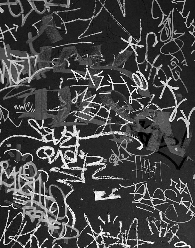 Black and white photograph of layers of graffiti tags on a door in downtown Madison, Wisconsin. The elaborate markings give the impression of an abstract painting.