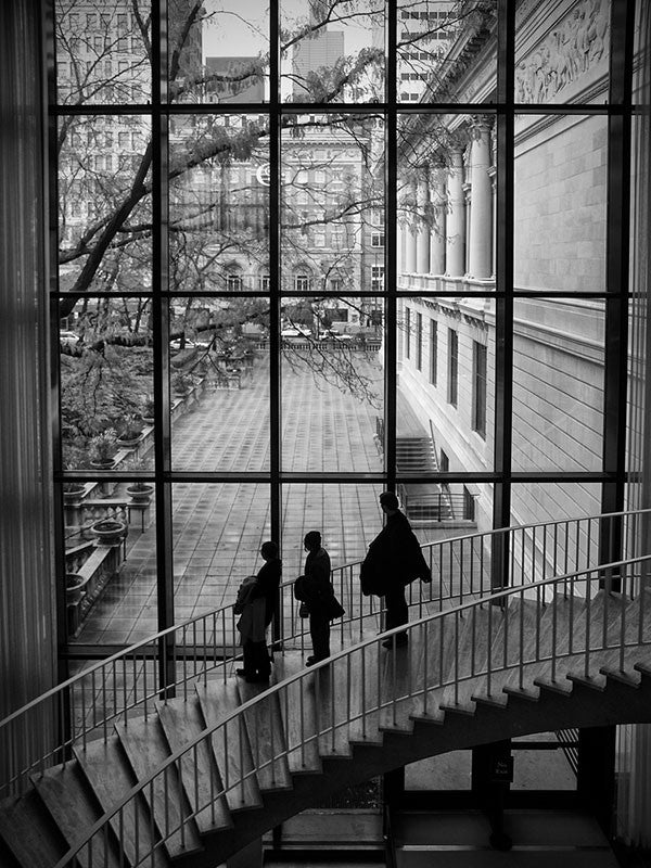 Black and white photograph inside the Art Institute of Chicago, with large windows looking out to Michigan Avenue in downtown Chicago.