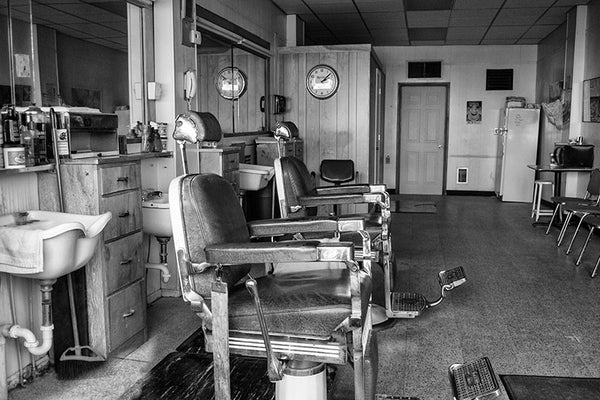 Black and white photograph inside a small town barber shop.