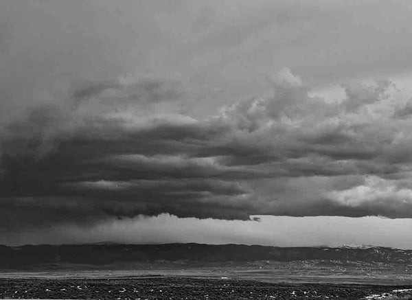 Black and white landscape photograph of dark, heavy storm clouds passing over Sheridan, Wyoming.