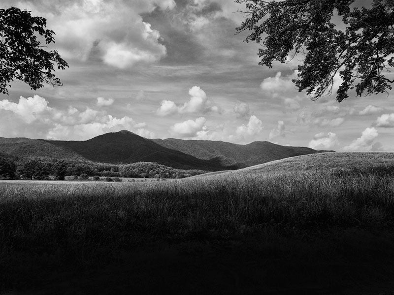 Black and white landscape photograph of the Smoky Mountains, as seen across the pasture at Cades Cove.