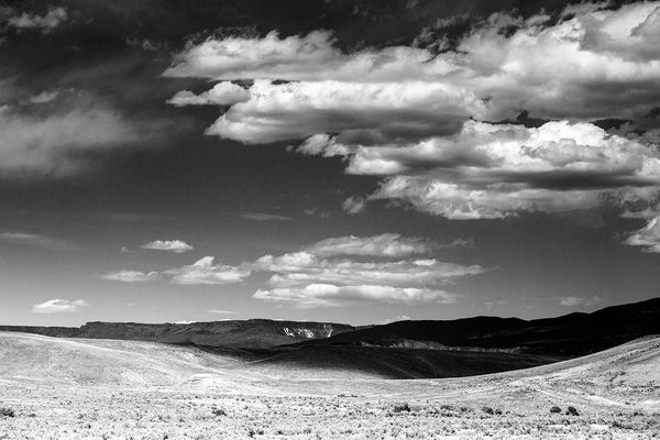 Black and white landscape photograph of Colorado foothills with cloud shadows.