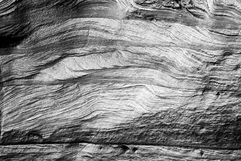 Black and white landscape photograph of natural stone textures along the walls of Canyon de Chelly in Arizona.