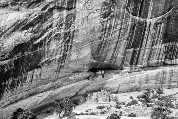 Black and white landscape photograph of the ancient Native American cliff dwellings known as the White House, deep in the canyon at Canyon de Chelly, Arizona.