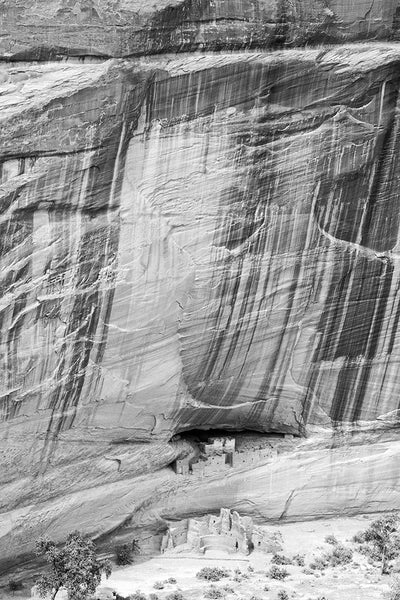 Black and white landscape photograph of the ancient ancestral Puebloan ruins known as the White House ruins in the floor of Canyon de Chelly in Arizona.