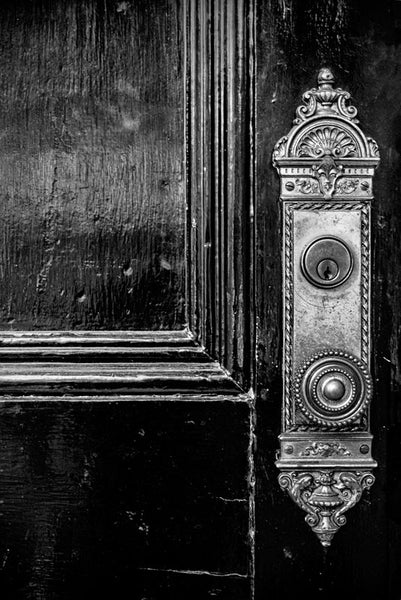 Black and white photograph of a black door with ornate brass knob and faceplate, found on the campus of Vanderbilt University in Nashville, Tennessee.