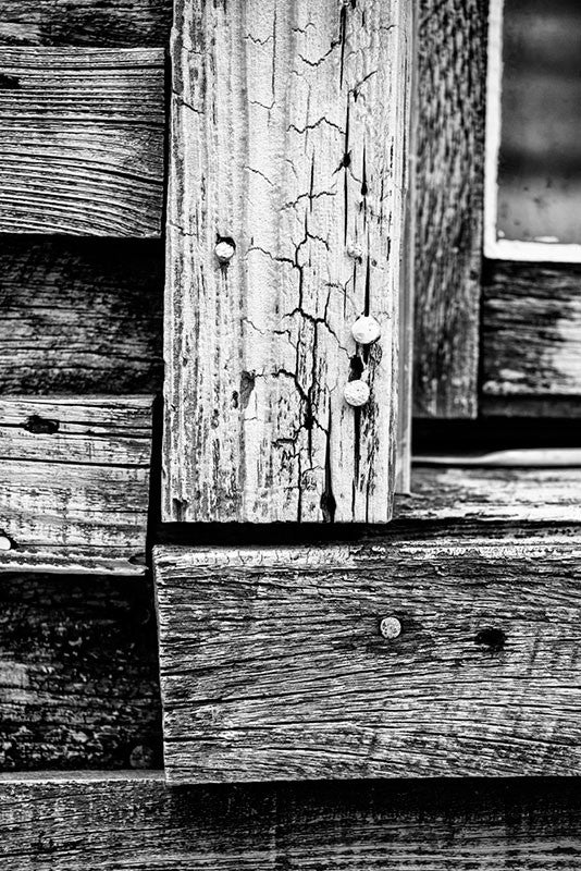Black and white photograph of weathered boards on the exterior of the home of late blues musician Sleepy John Estes in Brownsville, Tennessee. 