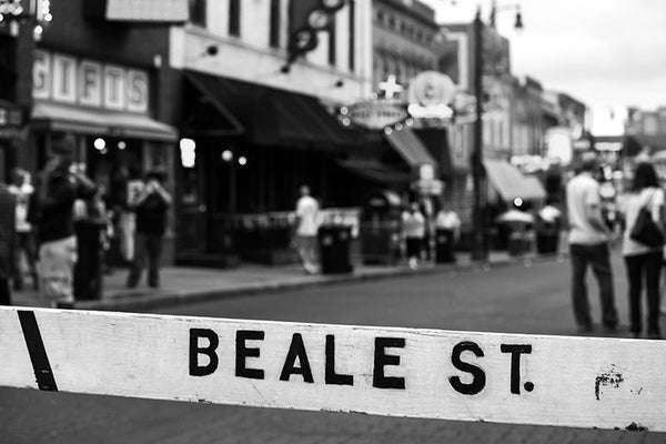 Black and white photograph of Memphis famous entertainment district on Beale Street, with the street name spray-painted on a street barricade.