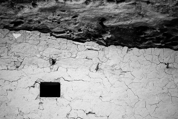 Black and white fine art photograph of a wall detail with a small window at Mesa Verde in Colorado.