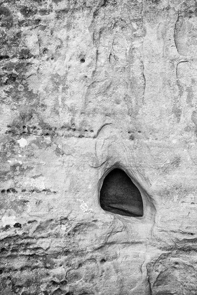 Black and white fine art photograph of an interesting stone formation in a rock wall face along the hiking trail at Mesa Verde, Colorado.