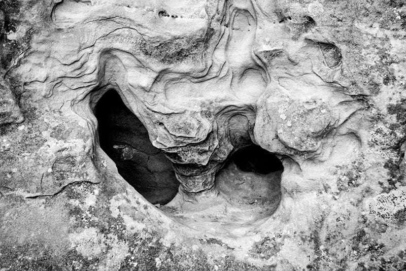 Black and white fine art photograph of an interesting stone formation in a rock wall face along the hiking trail at Mesa Verde, Colorado.