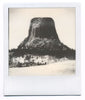 Polaroid-style one-of-a-kind instant photograph of a Wyoming's Devil's Tower surrounded by a winter landscape.  Archivally mounted and matted, and ready to fit an 11″ x 14″ frame. Signed by the artist on back of the print and on the back of the mount. Shot on Impossible Project film, this is a one-of-a-kind, unique photo. The imperfections of the exposure and the way the analog image developed are characteristic of the style of print, and make it imperfectly beautiful.  I've done my best to accurately repre