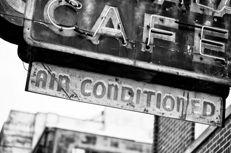 Black and white photograph of a fading, vintage neon cafe sign on Beale Street in Memphis.