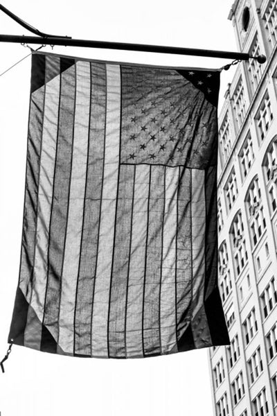Black and white photograph of a US flag hanging over the street in Memphis.