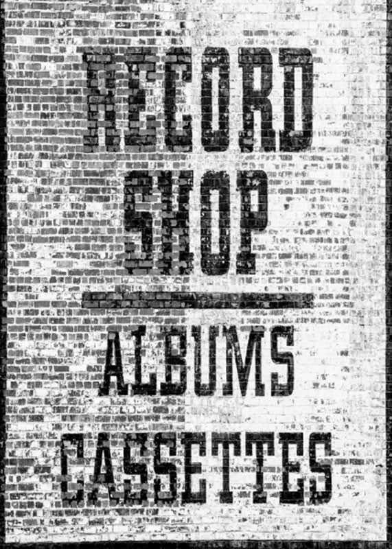 Black and white photograph of a two-story record store sign painted on the side of a brick wall in Nashville's Lower Broadway entertainment district.
